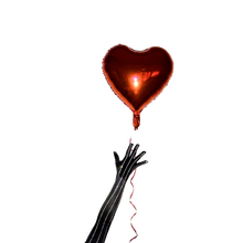 Load image into Gallery viewer, Red foil heart-shaped balloon with red ribbons on a white background being held by a black glove with crystal pinstripes.